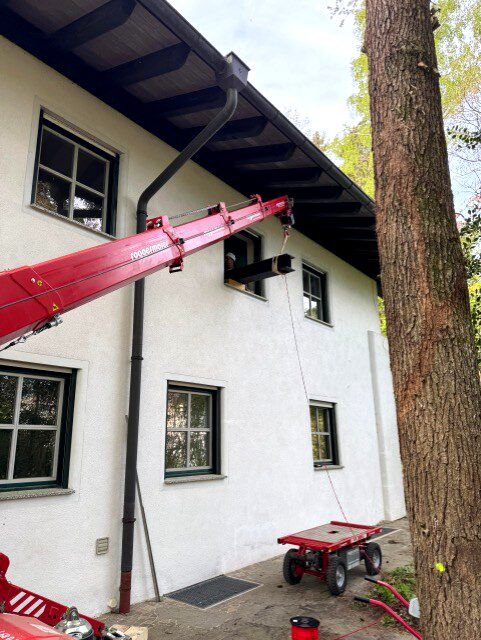 Minikran hebt Stahlträger durch Fenster